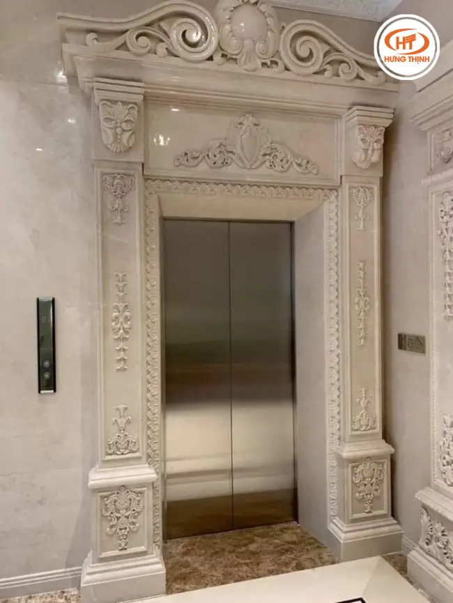Đá Marble Crema Marfil ốp mặt tiền thang máy với hoa văn chạm khắc tinh xảo