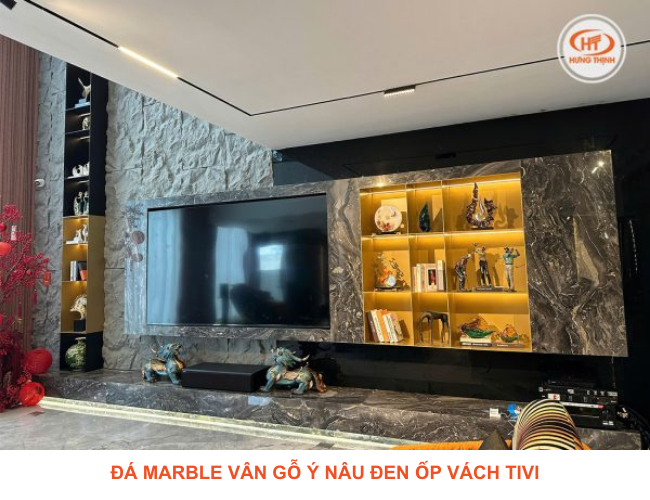 Gia chủ chọn đá Marble vân gỗ ý nâu đen ốp vách tivi cùng tông màu với nội thất