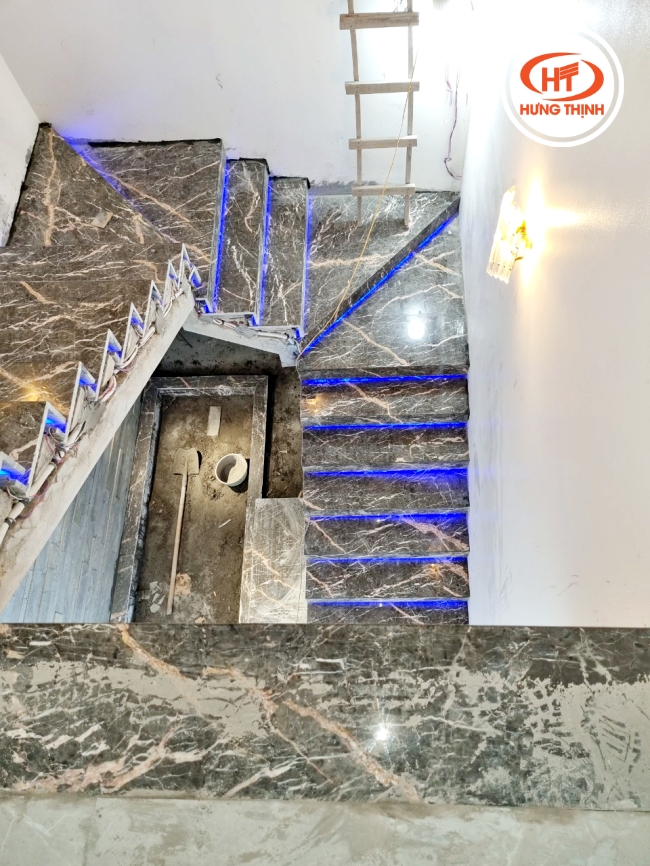 Cầu thang Marble Asia Network phối chân đèn led xanh lại tạo cảm giác huyền bí. 