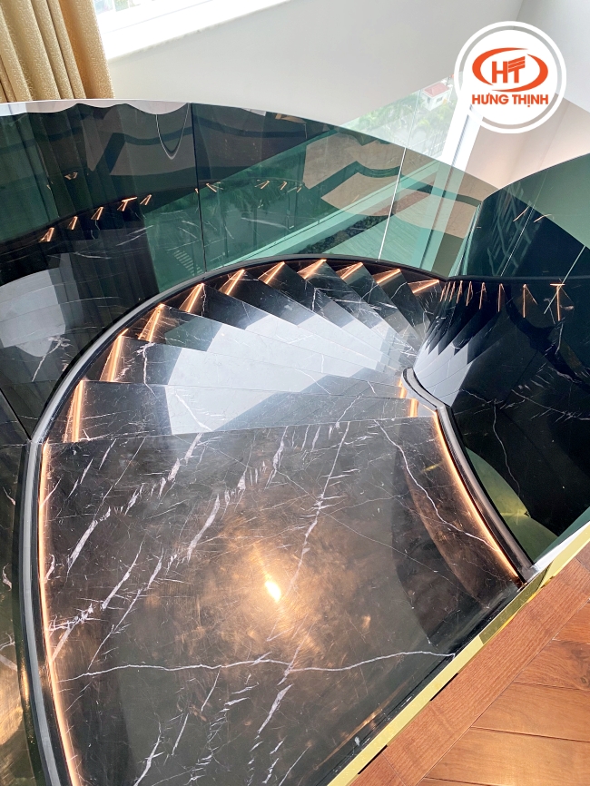 Cầu thang đá cẩm thạch Đen Chỉ Trắng phối lan can kính đen tạo điểm nhấn. 