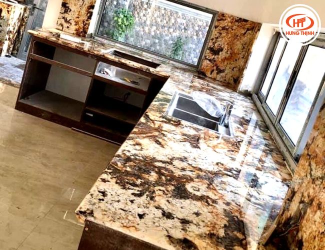 Bàn bếp và tường bếp gia đình ốp đá Royal Gold ấn tượng. 