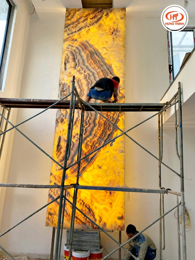 Hình ảnh đội thợ đang trong quá trình thi công lắp đặt tranh đá Thạch Anh xuyên sáng thông tầng