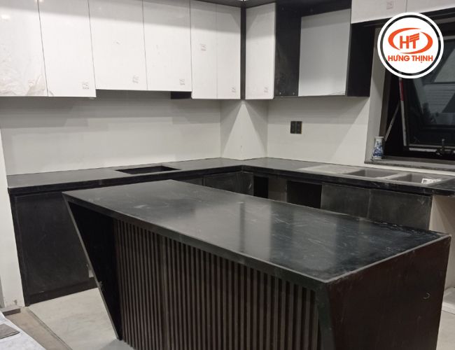 Bàn đảo và bàn bếp màu đen của đá Granite Via Lactea phối nội thất tủ bếp trắng thuận mắt.