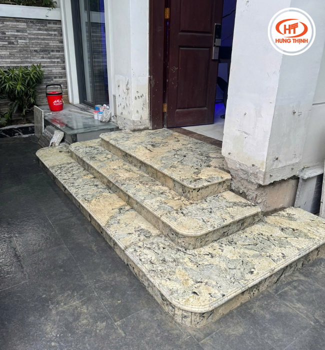 Tam cấp ốp đá với tông vàng kem cùng vân xám tự nhiên, mang lại cảm giác ấm áp, sang trọng