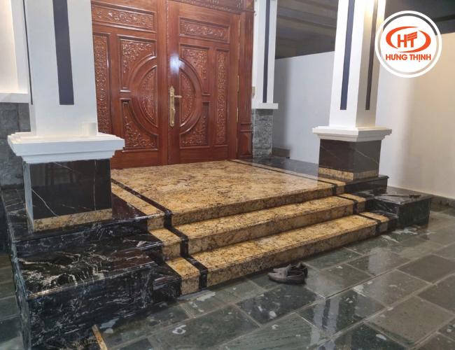 Tam cấp kết hợp đá granite Solarius và Black Forest tạo nên sự tương phản hài hòa, tăng chiều sâu cho mặt tiền