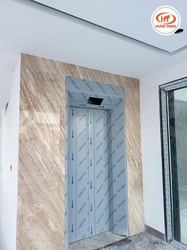 Tổng thể thang máy ốp đá Marble Vân Gỗ Chéo