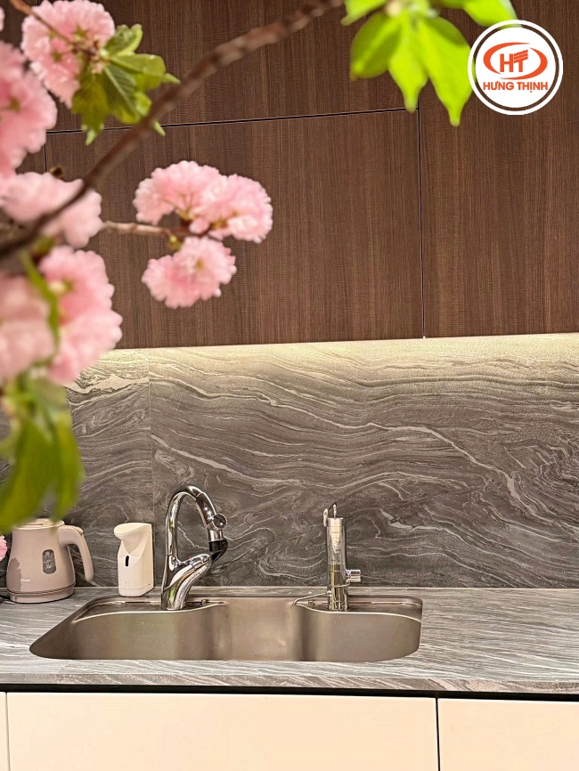 Mẫu đá ốp tường bếp và bàn bếp màu xám vân gỗ tạo cảm giác gần gũi, ấm áp
