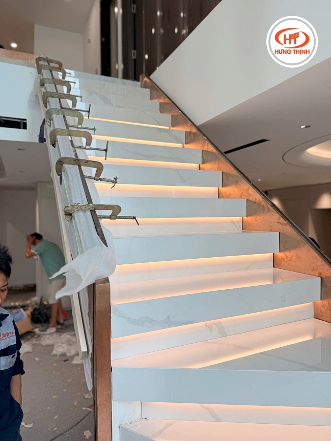 Cầu thang đá Nung Kết Suite Carrara kết hợp với hệ đèn LED âm bậc tạo điểm nhấn cho không gian